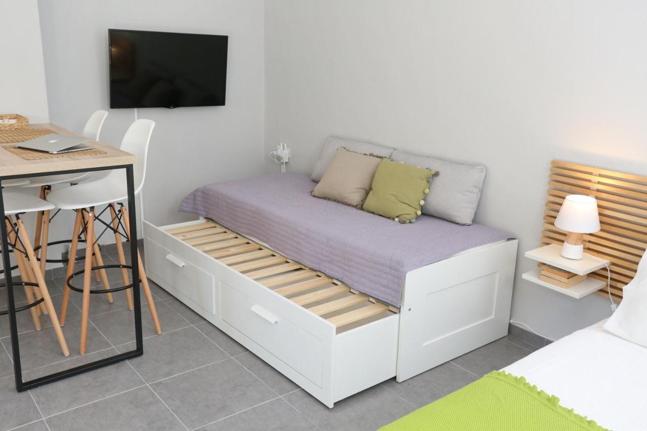 Pull-out trundle daybed with storage drawers beside a high dining table