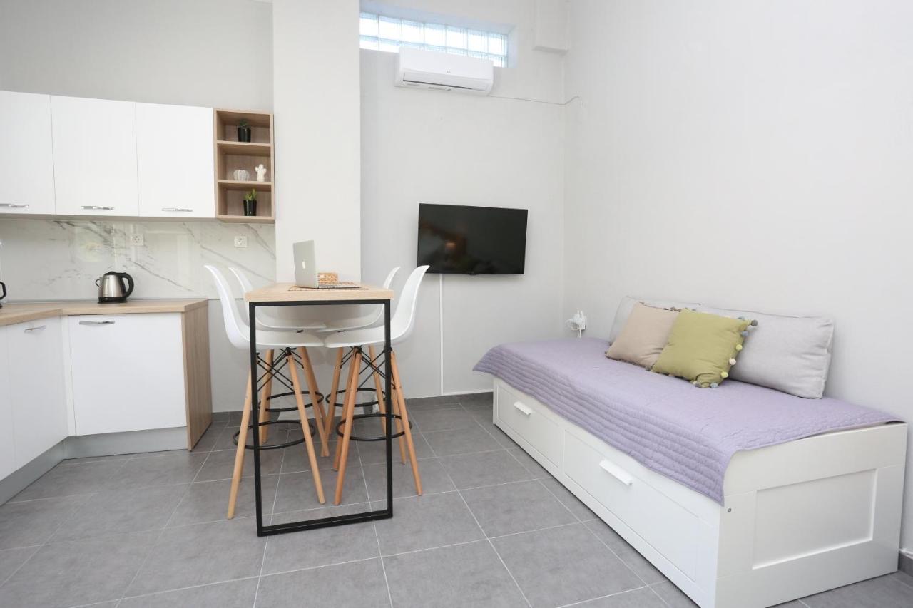 Modern living area with sofa bed, wall-mounted TV, and high dining table
